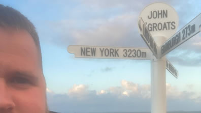 Man standing by a signpost