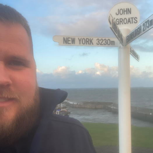 Man standing by a signpost